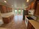 Well-lit kitchen featuring wood cabinets, tile floors, modern appliances, and bay windows at 11304 Niagara St, Thornton, CO 80233