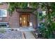Brick building entrance with wood door and small landscaped area at 1620 Colorado Blvd # 6, Denver, CO 80220