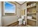 Comfortable bathroom offers a scenic window view, toilet, built-in shelving, and modern decor at 4255 S County Road 185, Byers, CO 80103