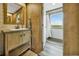 Bathroom features a wood vanity with storage, undermount sink, modern faucet, and an adjacent walk-in shower with a scenic window view at 4255 S County Road 185, Byers, CO 80103