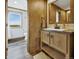 Bathroom features a wood vanity with storage, undermount sink, modern faucet, and an adjacent toilet area with a scenic window view at 4255 S County Road 185, Byers, CO 80103