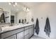 Bathroom features a large mirror over a double sink vanity with gray cabinetry and a large walk-in shower at 296 N Newcastle Way, Aurora, CO 80018
