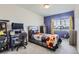 Bright bedroom with a study desk area, gray carpet, and colorful decor for and gamers at 296 N Newcastle Way, Aurora, CO 80018