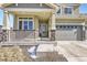 Inviting front porch with stone accents, a cozy railing, and close up of the home's entrance at 296 N Newcastle Way, Aurora, CO 80018