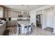 An open kitchen features gray cabinetry, an island with seating, and stainless steel appliances at 296 N Newcastle Way, Aurora, CO 80018