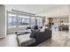 Open-concept living room with large windows and hardwood floors that connect to the kitchen area at 296 N Newcastle Way, Aurora, CO 80018