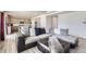 Bright living room featuring a sectional sofa, a decorative ottoman and a modern open kitchen at 296 N Newcastle Way, Aurora, CO 80018