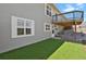 Backyard with artificial turf, a deck, and the exterior of a gray home at 3596 Longs Peak Cir, Parker, CO 80138