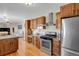 Bright kitchen with stainless steel appliances, wood cabinets, and hardwood flooring at 3596 Longs Peak Cir, Parker, CO 80138