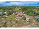 Aerial view of a large property with a home, fire pit, pool, and surrounding yard with trees and landscaping at 14030 E Progress Way, Aurora, CO 80015