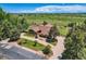 Aerial view of a sprawling property showcasing a large home, circular driveway, and mature landscaping at 14030 E Progress Way, Aurora, CO 80015