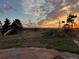 Landscaped backyard with play structure, windmill, and mountain views at sunset at 14030 E Progress Way, Aurora, CO 80015