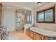 Bathroom features glass shower, soaking tub, and wood cabinets under granite countertops at 14030 E Progress Way, Aurora, CO 80015