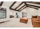 Spacious living room with exposed beams, a cozy seating area, and an open floor plan for gatherings at 14030 E Progress Way, Aurora, CO 80015