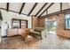 Cozy living room with brick accents, an open layout, and abundant natural light, offering a welcoming ambiance at 14030 E Progress Way, Aurora, CO 80015