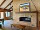 Open living room featuring brick fireplace with wooden mantle and beamed vaulted ceilings at 14030 E Progress Way, Aurora, CO 80015