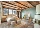 Spacious primary bedroom with wood-beamed ceiling and ensuite bathroom at 14030 E Progress Way, Aurora, CO 80015