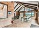 Bright sunroom with brick walls, large windows, and a dining area, perfect for enjoying natural light and views at 14030 E Progress Way, Aurora, CO 80015
