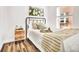 Inviting bedroom featuring a black metal bed frame, wood nightstand, and hardwood floors at 1629 N Clarkson St # 23, Denver, CO 80218