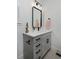 Stylish bathroom vanity with gray cabinets, modern hardware, quartz countertop, and black framed mirror at 10866 Lyric St, Lone Tree, CO 80134