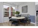 Chic dining area with modern table, black chairs, and view of the streetscape through a large window at 10866 Lyric St, Lone Tree, CO 80134