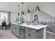 Modern kitchen island with quartz countertops, stylish pendant lights, stainless steel appliances, and gray cabinetry at 10866 Lyric St, Lone Tree, CO 80134