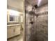 Modern bathroom featuring a glass shower, tiled walls, and updated vanity at 9017 E Oxford Dr, Denver, CO 80237