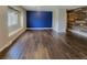 Large living room featuring sleek hardwood floors and a striking accent wall at 9017 E Oxford Dr, Denver, CO 80237
