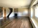 Spacious living room with wood floors, brick fireplace, and an open staircase at 9017 E Oxford Dr, Denver, CO 80237