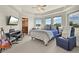 Bedroom with multiple windows, a bed with soft pillows, a guitar, and a relaxing chair at 1287 Buffalo Ridge Rd, Castle Pines, CO 80108