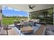 Spacious covered patio with comfortable seating, an outdoor fan, and views of the expansive yard at 1287 Buffalo Ridge Rd, Castle Pines, CO 80108