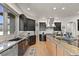 Modern kitchen with dark cabinets, stainless steel appliances, and a large island with stone countertops at 1287 Buffalo Ridge Rd, Castle Pines, CO 80108