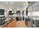Modern kitchen with stainless steel refrigerator and appliances, dark cabinets, and stone countertops at 1287 Buffalo Ridge Rd, Castle Pines, CO 80108