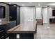 Modern finished basement with a stylish wet bar featuring dark cabinetry and a unique marble countertop island at 3439 Uinta St, Denver, CO 80238