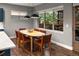 Bright dining area features an oval table, six chairs, and large windows, providing a warm and inviting atmosphere at 3439 Uinta St, Denver, CO 80238
