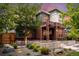 Landscaped front yard features a modern brick home with mature trees and manicured gardens at 3439 Uinta St, Denver, CO 80238