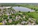 Aerial view of a lakeside community with mature trees, neighborhood park, and walking path at 3144 Stevens N Cir, Erie, CO 80516