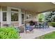 Covered back patio featuring a dining set, grill, and seating area at 3144 Stevens N Cir, Erie, CO 80516