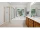 Bright bathroom featuring a soaking tub, shower, and vanity with a large window view at 3144 Stevens N Cir, Erie, CO 80516