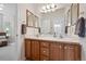 Bathroom with double sinks, wood cabinets and a large mirror at 3144 Stevens N Cir, Erie, CO 80516