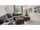Spacious living room with a large sectional couch, ottoman, and a bright window view at 3144 Stevens N Cir, Erie, CO 80516