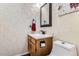 Stylish half bathroom features modern fixtures, including a wood vanity and decorative wallpaper at 19725 Rosewood Ct, Parker, CO 80138