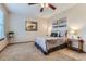 Bedroom with tan carpet, ceiling fan, queen bed, neutral walls, and warm lamps at 19725 Rosewood Ct, Parker, CO 80138