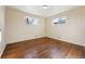 Empty bedroom with hardwood floors and two windows at 10502 Washington Way, Northglenn, CO 80233