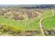 Picturesque aerial shot of sprawling land with a dirt road winding through lush greenery towards the horizon at 3794 N State Highway 67, Sedalia, CO 80135