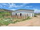 Exterior view of a large barn structure with metal fencing, perfect for housing animals at 3794 N State Highway 67, Sedalia, CO 80135