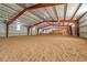 Vast interior of the horse barn with a sand floor, tall ceilings, and metal framing at 3794 N State Highway 67, Sedalia, CO 80135