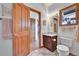 Well-lit bathroom with a modern vanity, toilet, and warm wood accents at 3794 N State Highway 67, Sedalia, CO 80135