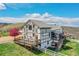 Back exterior of home featuring multi-level decks, tudor-style trim, a fenced yard and mature landscaping at 3794 N State Highway 67, Sedalia, CO 80135