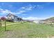 Spacious two-story home with a deck and white fencing, complemented by a barn in the background at 3794 N State Highway 67, Sedalia, CO 80135
